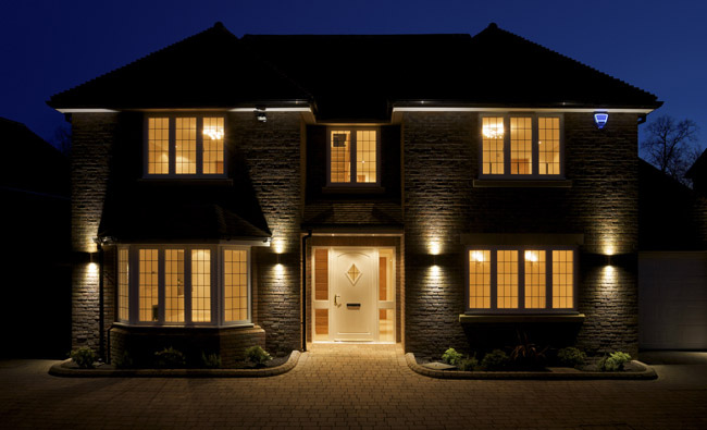 Residential home with outdoor security flood lights on at night.