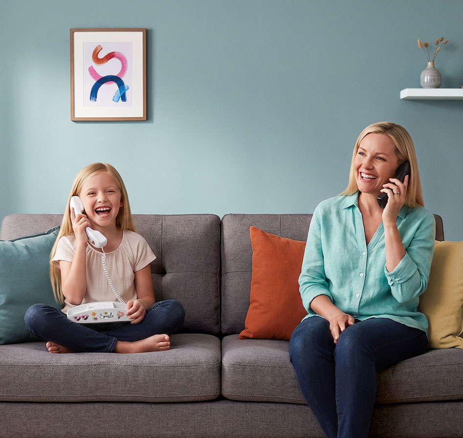 Mom and daughter using Ooma home phones in the living room